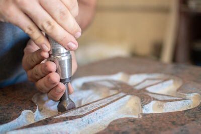 man hands bushhammered a tombstone in a workshop, work concept