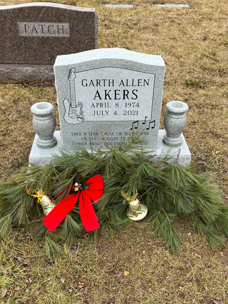 Single upright monument crafted in polished granite with custom engraving, standing as a classic tribute in a peaceful cemetery setting.