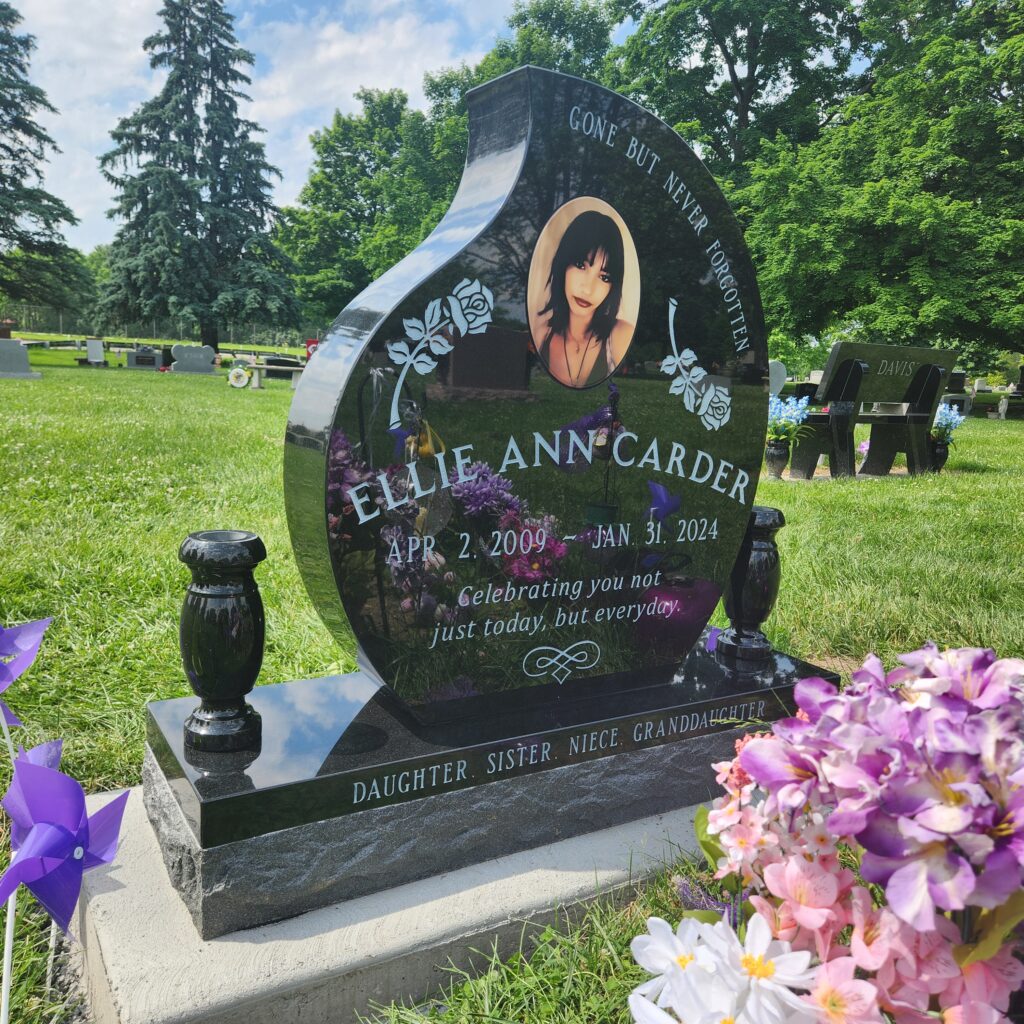 Single upright granite monument with finely engraved lettering, offering a traditional and lasting tribute in a peaceful cemetery setting.