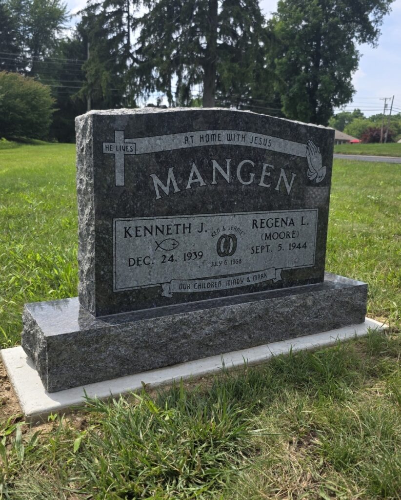Companion upright monument headstone in polished granite with dual name engraving and decorative design in a memorial park