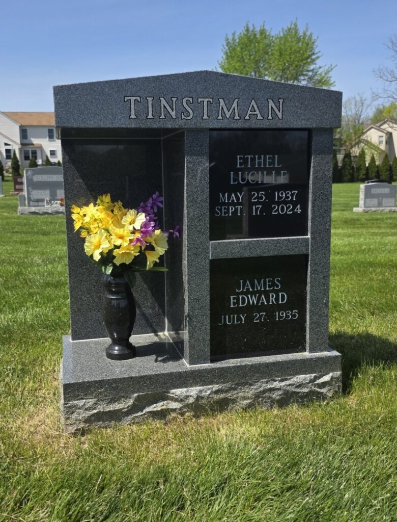 Two-niche cremation columbarium with center alcove for memorial display in a peaceful cemetery setting.