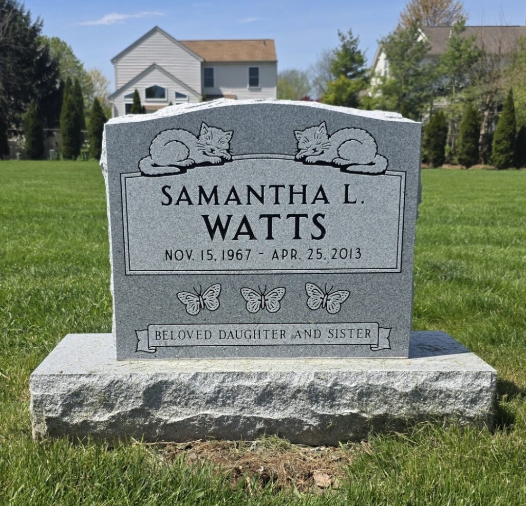 Single flat grave marker in granite with custom engraving, set flush to the ground in a peaceful cemetery setting.