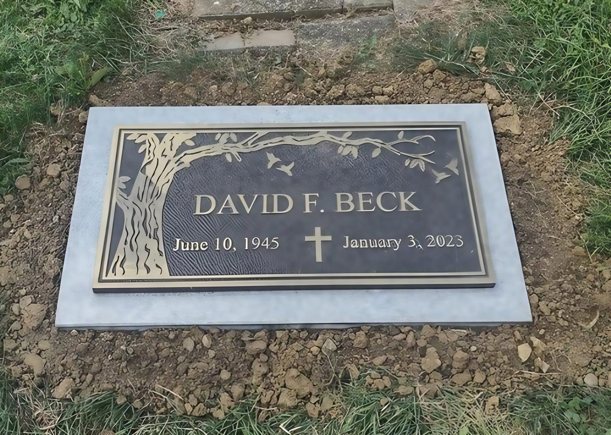 A custom bronze grave marker mounted on a sturdy granite base, installed in a Tipp City, Ohio cemetery.