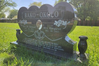 A side angle view of a granite monument on its base, highlighting the thick, durable construction and professional cemetery installation.